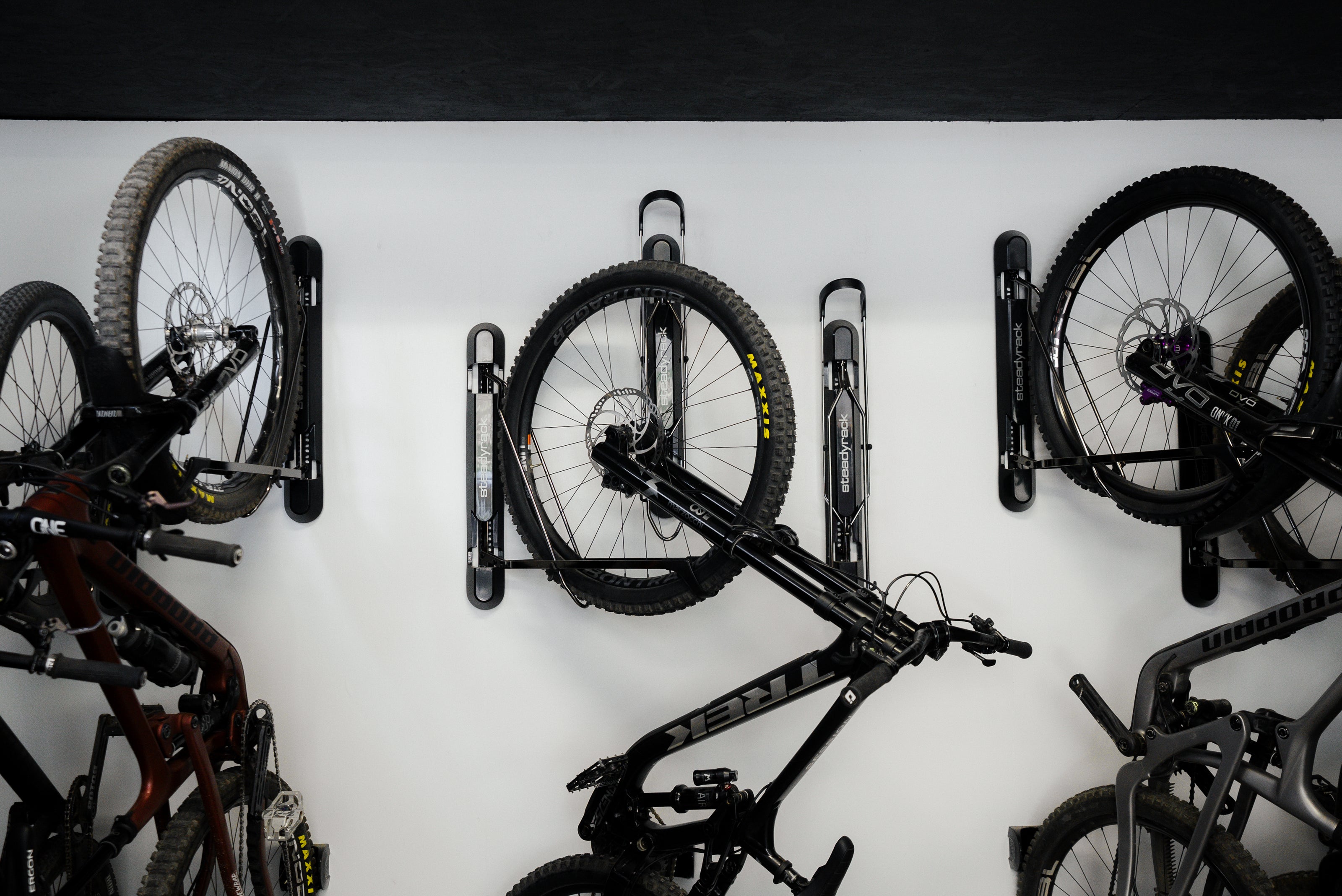 Bicycles mounted on a wall-mounted bike rack against a white background