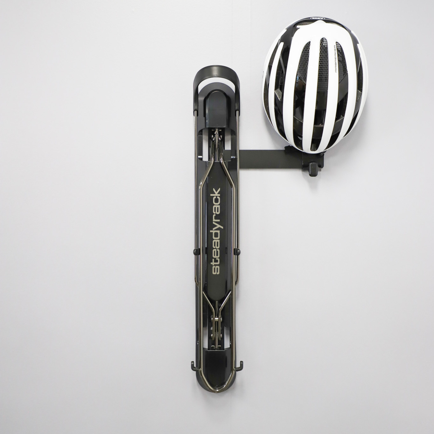 Bike rack with a helmet being stored on a hook on a white background. 