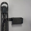 A person placing an electric bike charger into a GearMate Small SteadyBin attached with a bracket to a bike rack. 